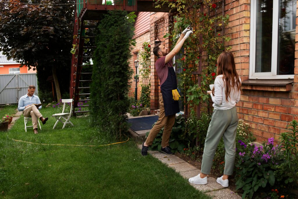 A man prunes plants on a brick wall